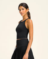 Joueuse portant la Brassière Wilson The Daily Brami Black sur le terrain de padel